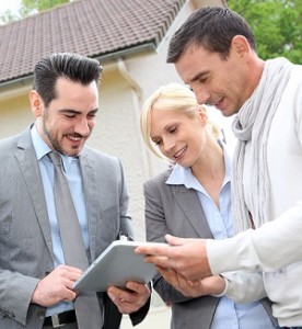 Real estate agent and his buyer clients using a tablet