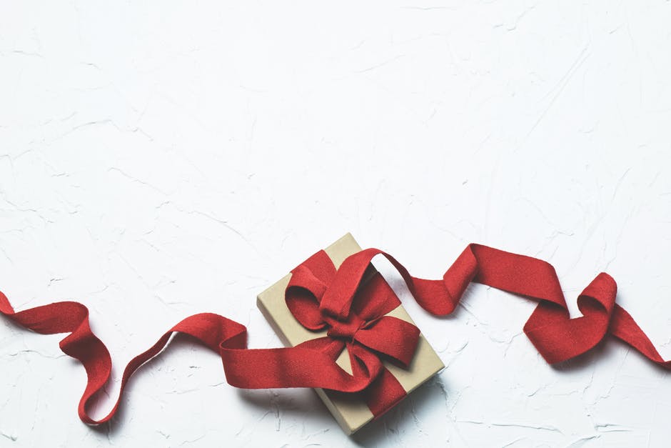 present with red bow and ribbon, white backdrop