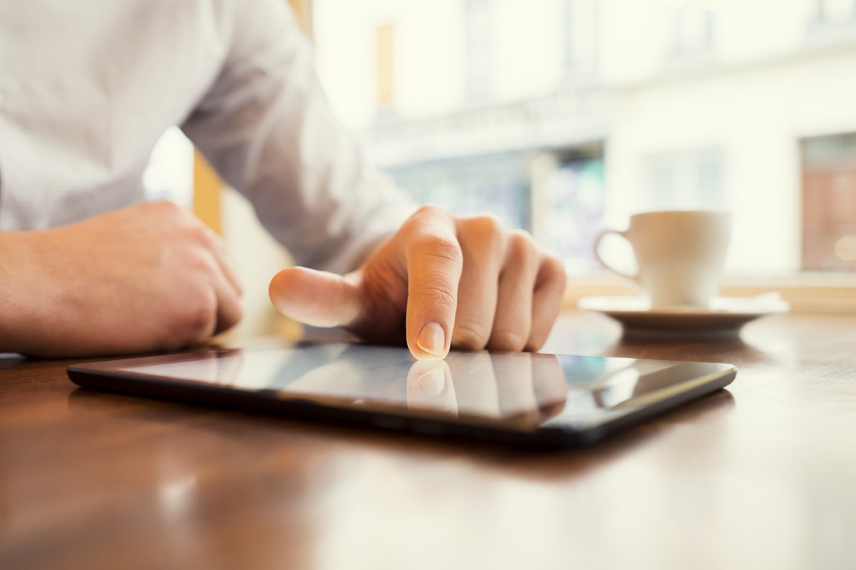 Man in a cafe using tablet pc. Window background. Vintage filter