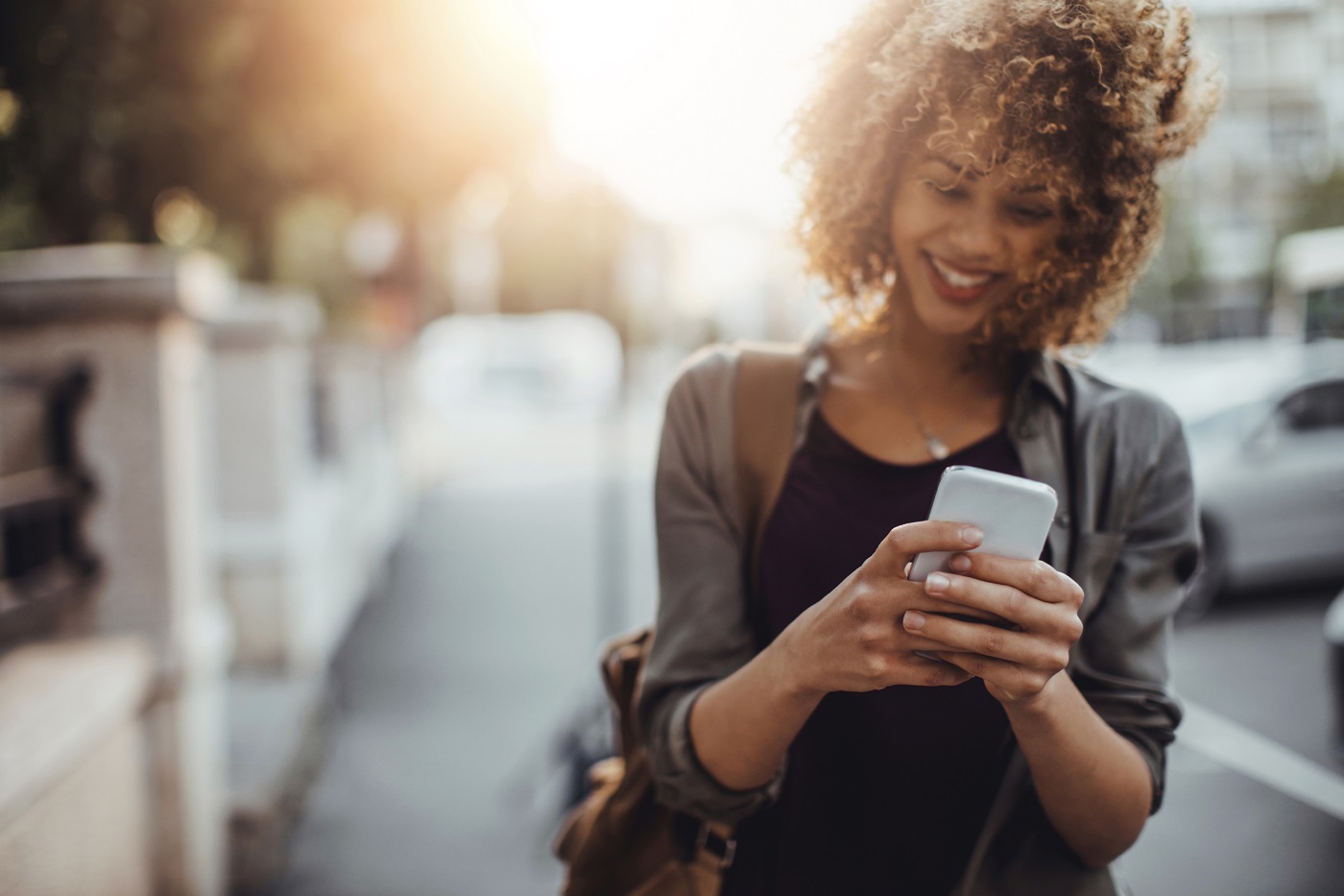 Photo of a woman using smart phone in city